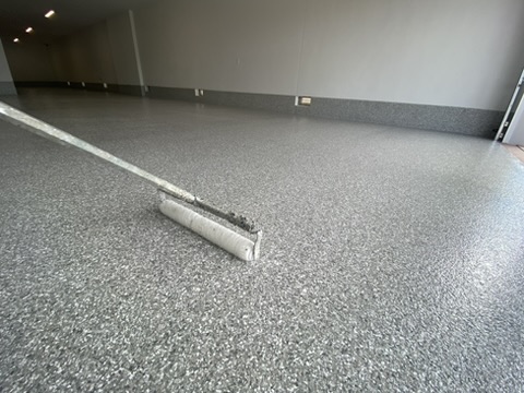 Flake epoxy garage floor being rolled out during installation in Naples, FL
