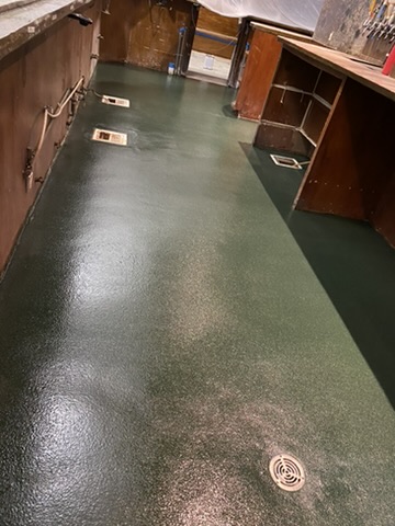 Dark green flake epoxy floor in a back-of-house space in Naples, FL