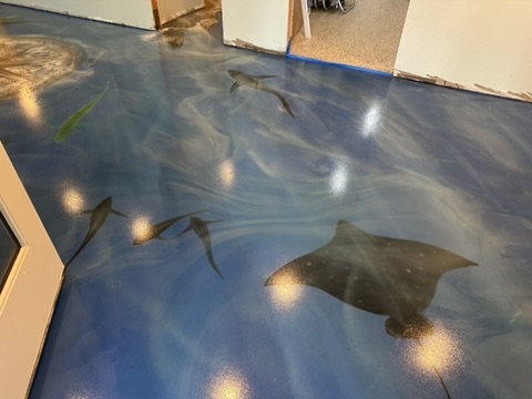Custom ocean-themed blue metallic epoxy floor with painted sea life in Naples, FL