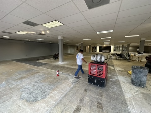 A ride-on grinder polishing a commercial concrete floor in Naples, FL
