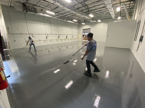 Heavy-duty solid epoxy floor being poured in an industrial space in Naples, FL