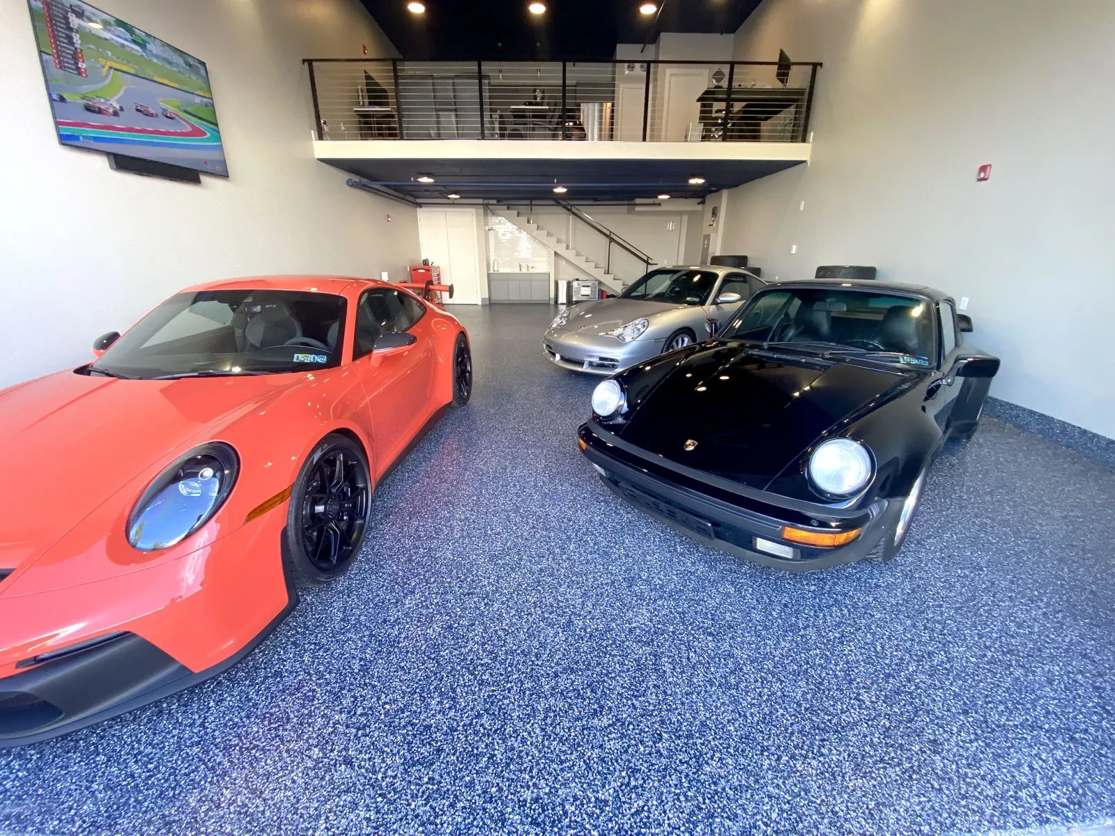 Multi-Porsche residential garage with deep navy flake epoxy floor
