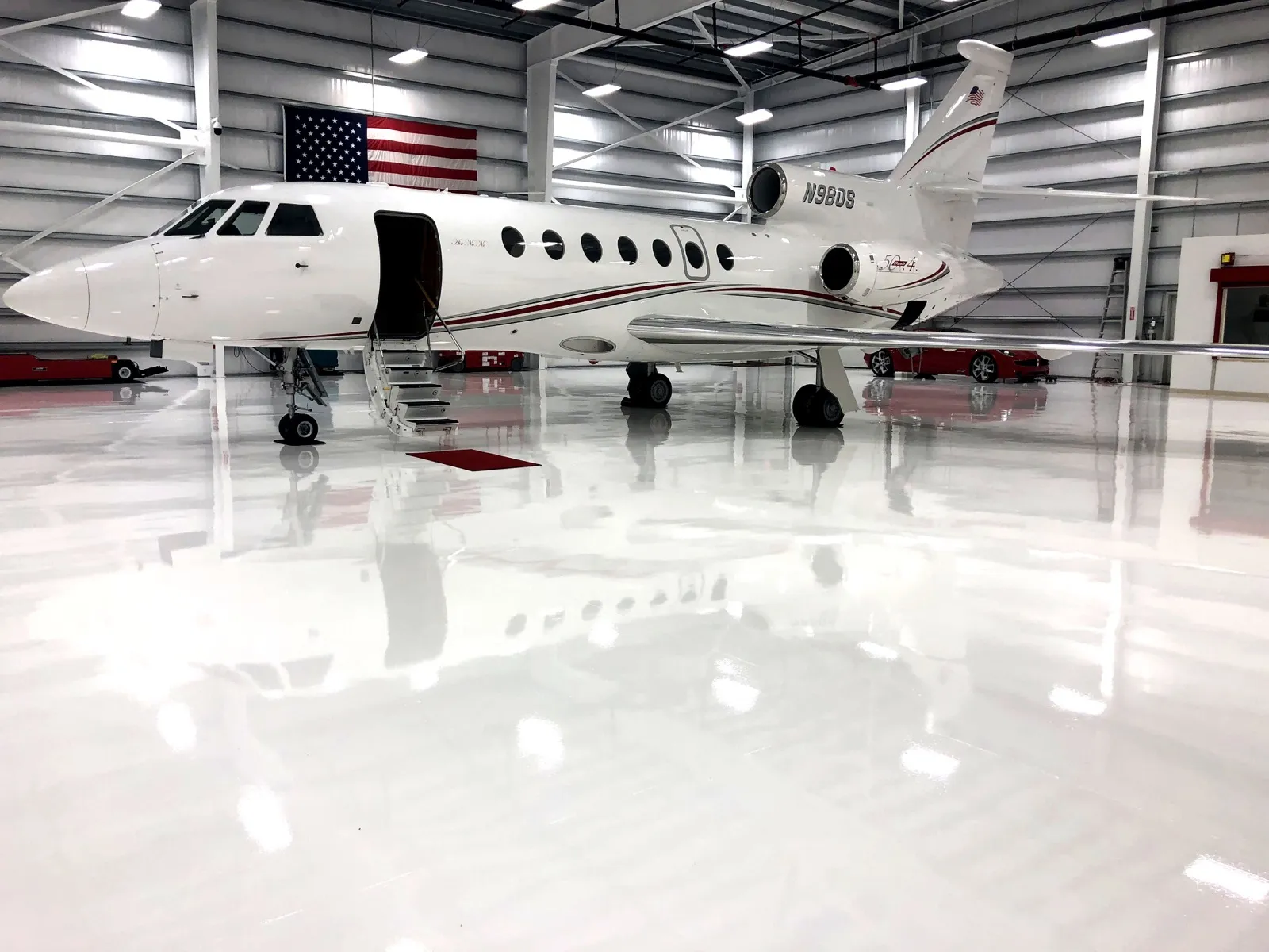 Private-jet hangar with high-gloss white epoxy floor